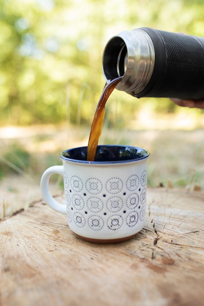 Free photo flask pouring coffee into cup