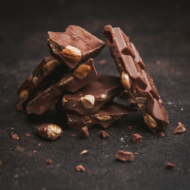 Free photo flat lay almonds with chocolate on dark brown textured.