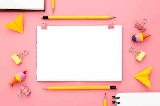 Flat lay arrangement of desk elements on pink background