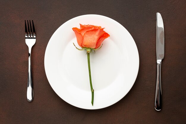 Flat lay arrangement for valentine's day dinner with orange rose