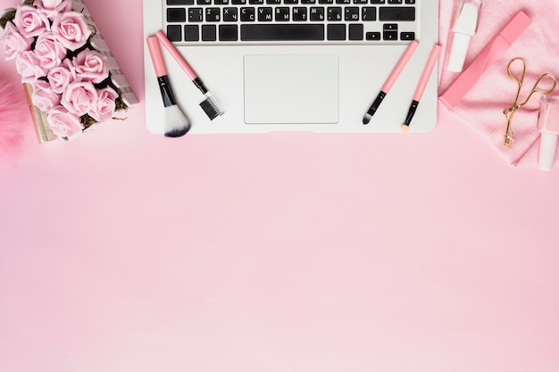 Flat lay arrangement with make-up brushes on laptop