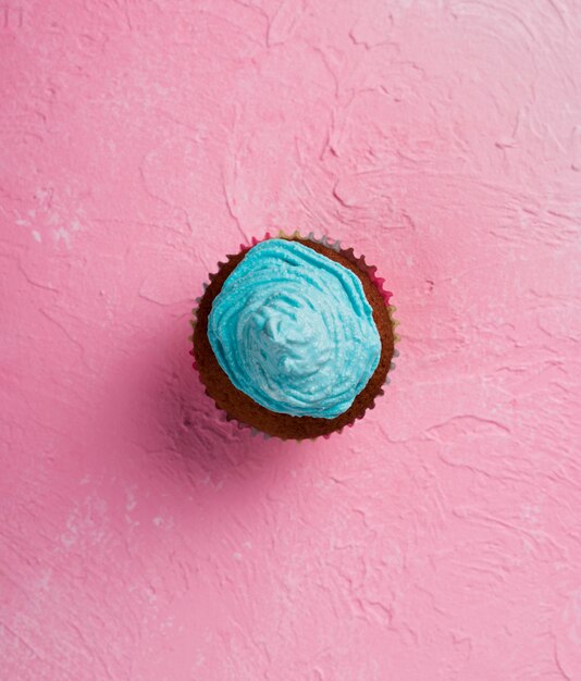 Flat lay arrangement with muffin on pink background