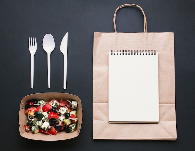 Free photo flat lay arrangement with notebook on paper bag