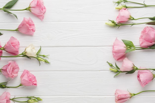 Free Photo flat lay arrangement with pink roses on wooden background