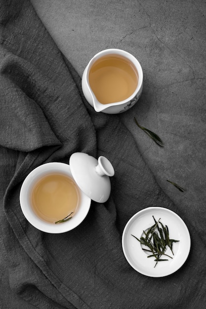 Flat lay arrangement with tea cups and herbs