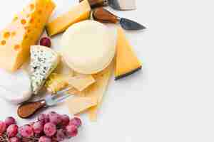 Free photo flat lay assortment of gourmet cheese with cheese knives