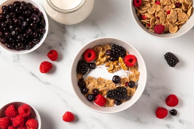 Flat lay assortment of healthy bowl cereals with berries