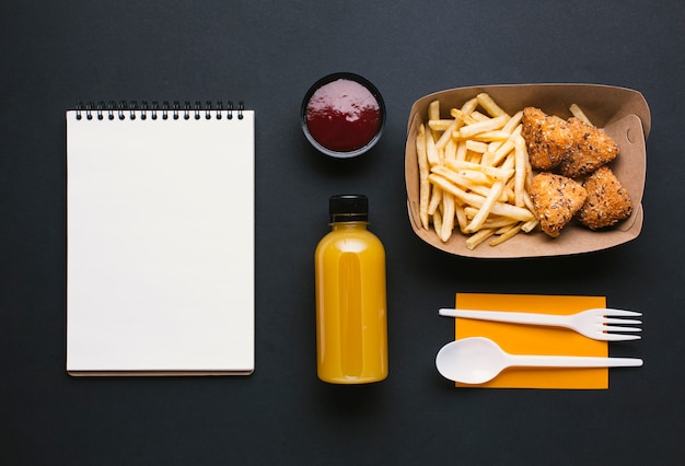 Flat lay assortment with fries and notebook