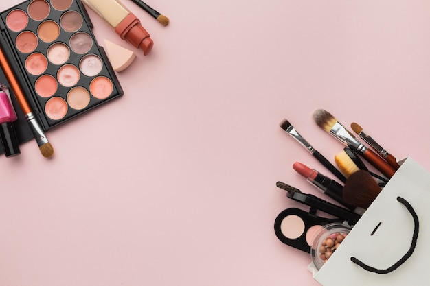 Flat lay assortment with make-up frame on pink background