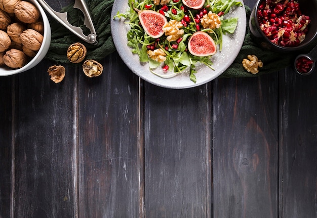 Free photo flat lay of autumn fig salad on plate with copy space and walnuts