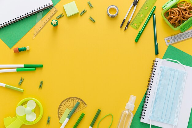 Flat lay of back to school materials with notebook and face mask