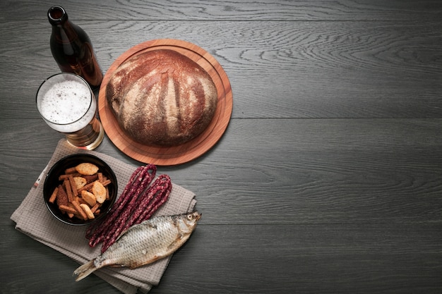 Flat lay beer glass and bottle with food platter with copy space