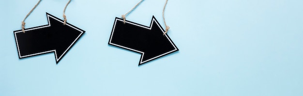 Free Photo flat lay black arrows on blue background with copy-space