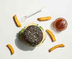 Free photo flat lay of black burger with fries