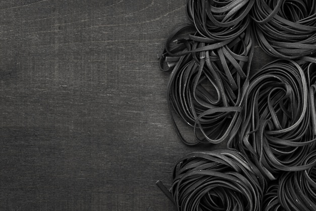 Flat lay of black tagliatelle with copy space