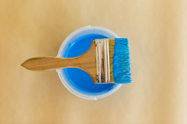 Free photo flat lay of blue paint and paint brush