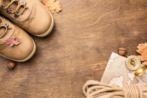 Flat lay of boots with rope and autumn leaves