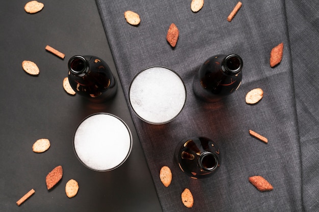 Flat lay bottles and glasses of beer with snacks