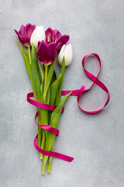 Free photo flat lay bouquet of tulips with pink ribbon