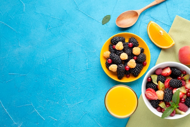 Free photo flat-lay bowl of fresh berries and fruits with copyspace