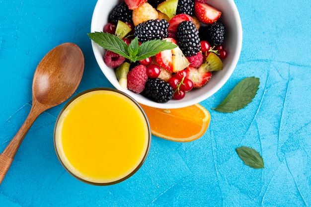 Free photo flat-lay bowl of fresh berries and fruits with juice