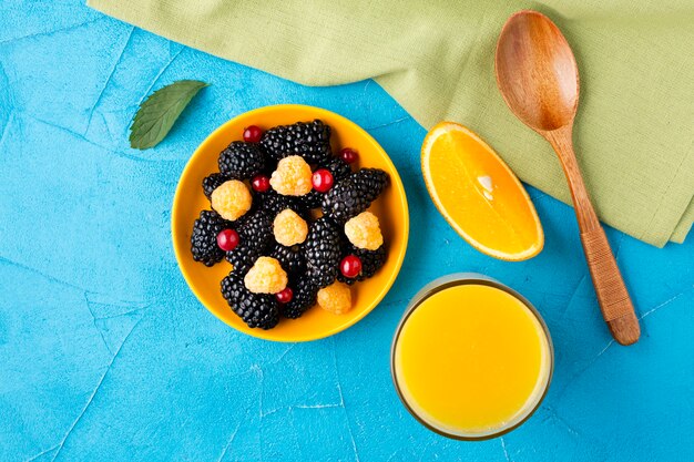 Flat-lay bowl of fresh berries and fruits with juice