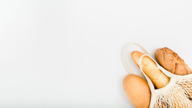 Flat lay of bread in reusable bag with copy space