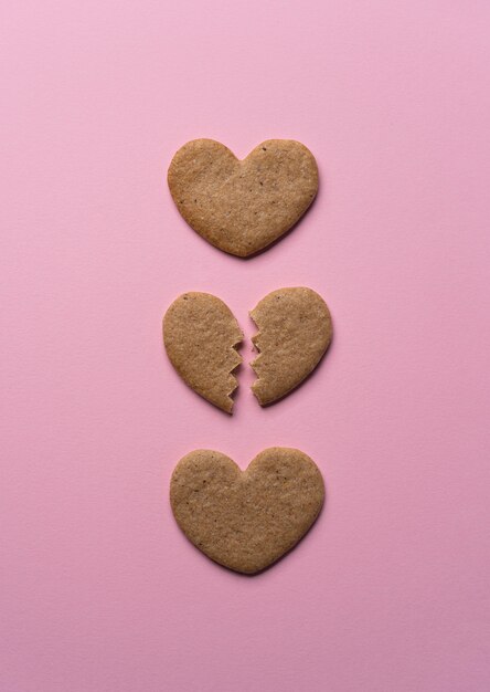 Flat lay broken cookie heart on pink background