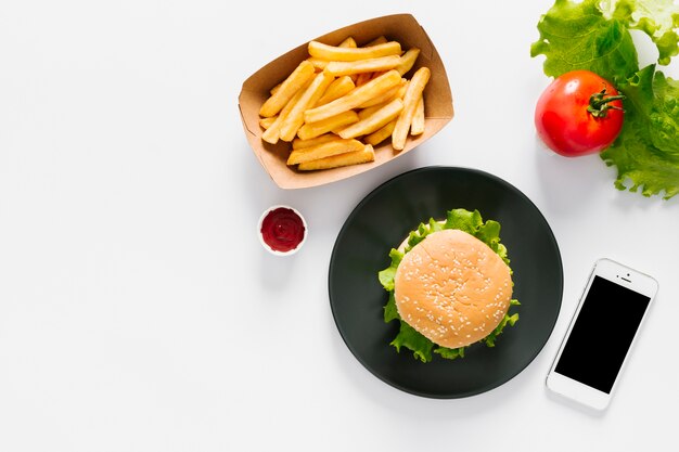 Flat-lay burger and fries on plate with copyspace