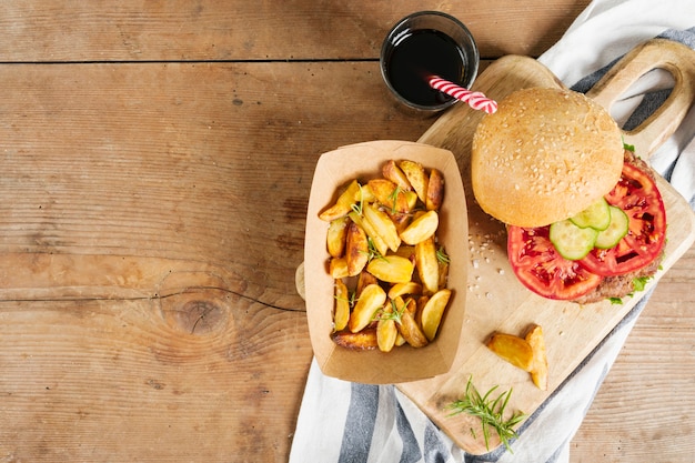 Flat-lay burger and fries on wooden board