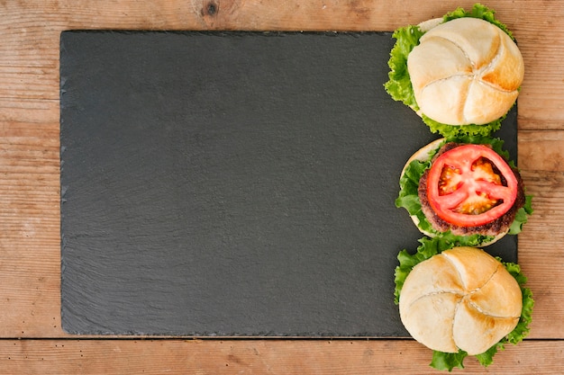 Free Photo flat-lay burger on slate with copyspace