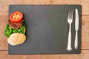 Free photo flat-lay burger on slate with copyspace