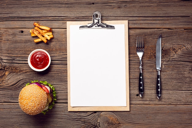 Free Photo flat lay burger with mock-up clipboard