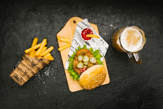 Free Photo flat-lay burger on wooden board with fries and beer