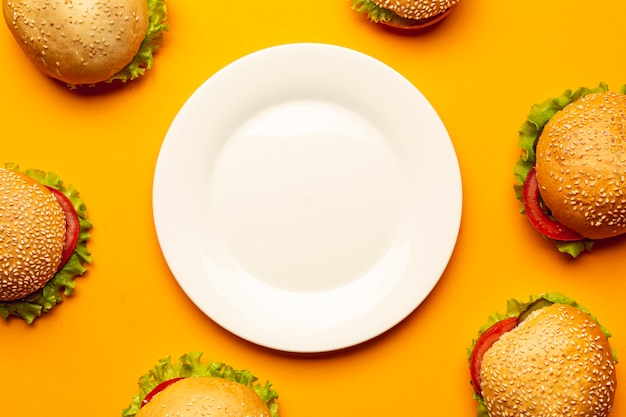 Free photo flat lay burgers with an empty plate