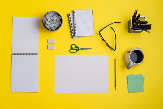 Free Photo flat lay business workplace with office supplies and coffee on yellow backdrop