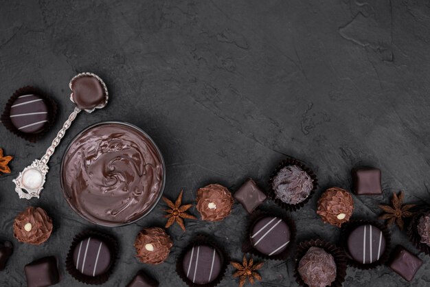 Flat lay candies and melted chocolate with copy space