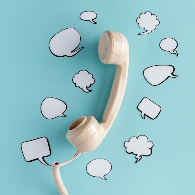 Flat lay of chat bubbles with telephone receiver