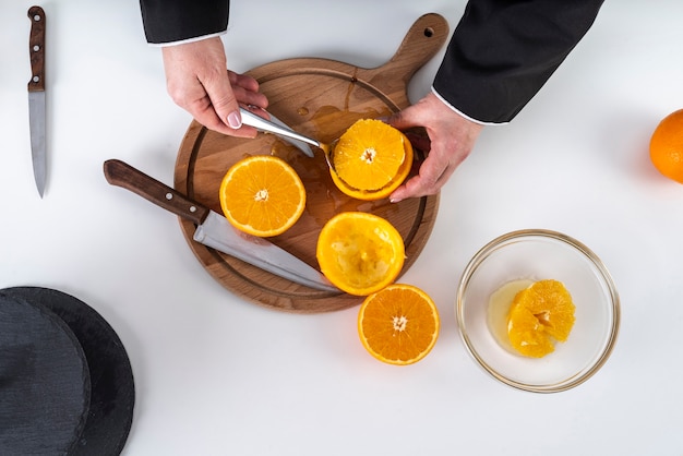 Free photo flat lay of chef cutting an orange