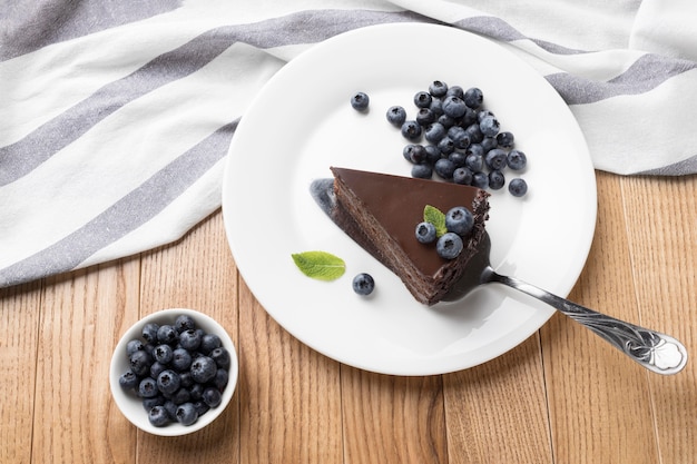 Flat lay of chocolate cake slice on plate with spatula