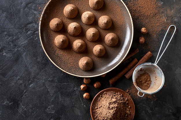 Free Photo flat lay of chocolate candy with cocoa powder and cinnamon sticks