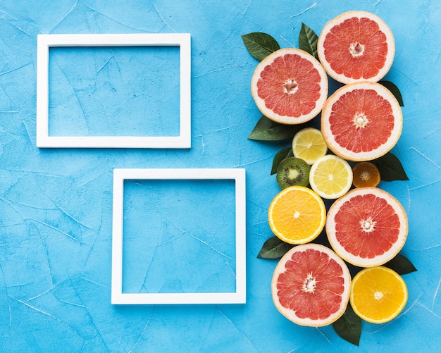 Free photo flat lay of citrus fruits and frames with copy space