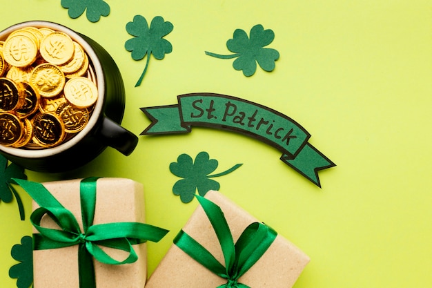 Free photo flat lay clovers and cauldron with gold