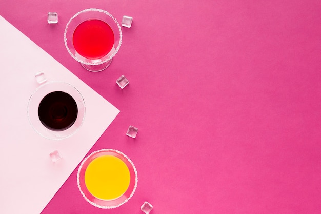 Free Photo flat lay of cocktail glasses with ice cubes and copy space