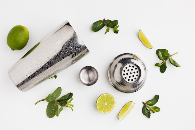 Flat lay of cocktail ingredients with shaker and mint