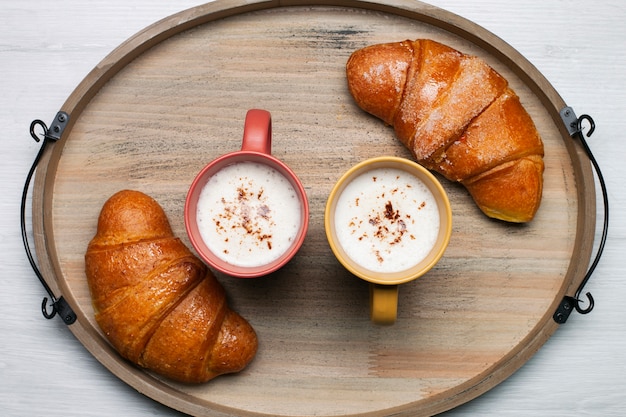 Flat lay coffee cups with croissants