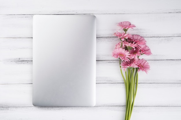 Flat lay composition of flowers and laptop