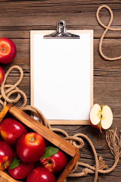 Free photo flat-lay crate with ripe apples with clipboard