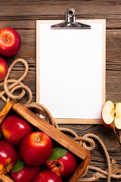 Free photo flat-lay crate with ripe apples with clipboard