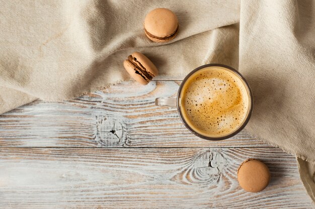 Flat lay of cup of coffee and macarons